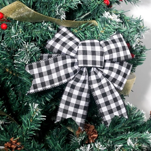 Christmas buffalo plaid bow with wire edges on a decorated pine tree branch