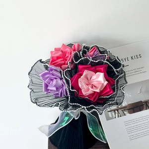 Detail of pink satin handmade flowers with black lace mesh and white pearl trim wrapping