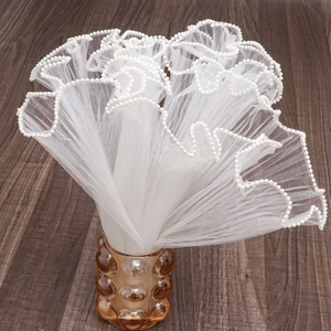 Elegant white mesh wrap with pearl edges in a decorative brown glass vase