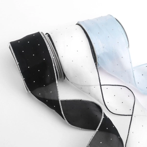 Close-up of three sparkling organza ribbons with silver glitter dots and stitched edges