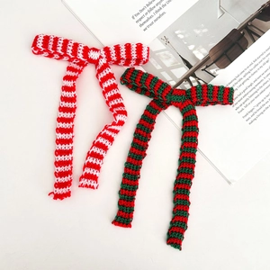 Vista macro de lazos navideños de punto con rayas rojas, verdes y blancas para regalos