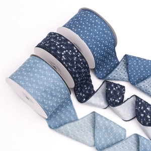 Three rolls of sequined denim ribbons in light, medium and dark blue for DIY crafts