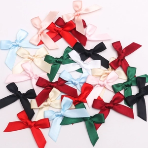 Gros plan de petits nœuds en ruban satin de 1cm colorés pour projets de couture et artisanat
