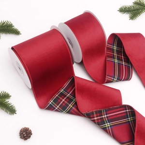 Dettaglio macro del nastro di velluto rosso con retro tartan e decori festivi