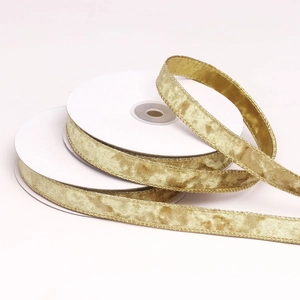 Detail view of two rolls of 1.5cm golden velvet ribbon with overlock edge for DIY decor
