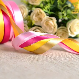 Close-up of 1cm colorful satin polyester ribbons in pink, yellow and gold colors