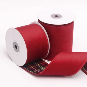 Dettaglio di nastro in velluto rosso con retro tartan e bordi cuciti per regali