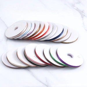 Top view of colorful polyester ribbon spools on white marble for DIY gift wrapping