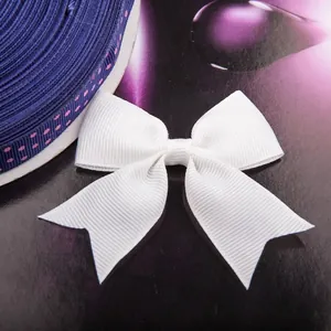 White grosgrain ribbon bow with navy polka dot fabric on a minimalist magazine background