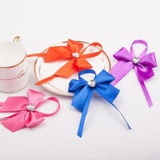 Detail of four colorful satin ribbons with heart-shaped faux diamonds for gift wrapping