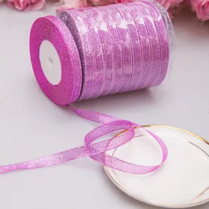 Nahaufnahme einer glitzernden pink-violetten Dekobandrolle auf einem weißen Porzellanteller