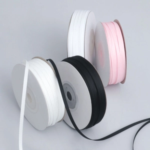 Close-up of 3mm ribbed grosgrain ribbon rolls in black, white, and pink for gift wrapping