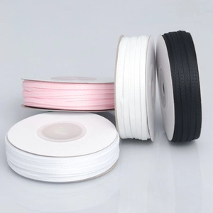 Rolls of 0.3cm ribbed grosgrain ribbon in pink, white, and black for gift wrapping