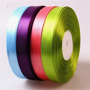Detailed close-up of 2cm silk satin ribbon rolls in sky blue, purple, pink, and green