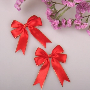 Detail of red satin bow with gold metallic edge for gift box and cake decoration