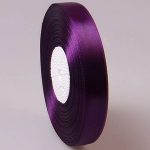 Detail of dark purple satin ribbon roll with smooth silk texture for gift wrapping