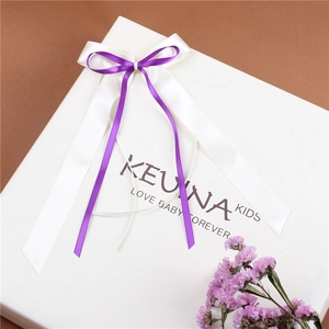 Elegant white square gift box featuring a layered purple and white satin ribbon bow