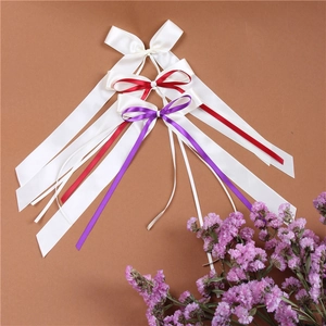 Close-up of elegant satin bow streamers in white, red and purple for wedding decor