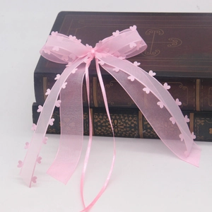 Nœud en organza rose avec bordure cœur sur livres anciens pour décor de mariage