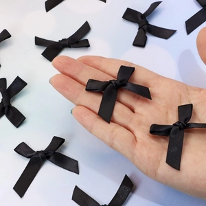 Close-up of small black polyester ribbon bows for DIY garment and hair accessories