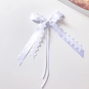 Detailed view of white lace ribbon bow with heart cutouts for elegant gift packaging