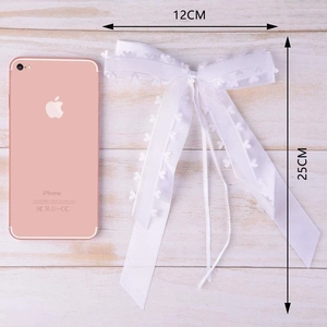 Detail view of a white heart lace ribbon bow with 12cm width and 25cm length