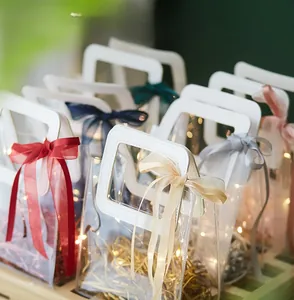 Detail of luxury PVC gift bags with satin ribbons and LED light string decor