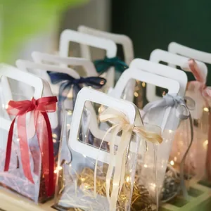 Transparent PVC gift bags with leather handles, colorful ribbons and warm LED string lights