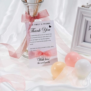 Detail of 2.5cm pink organza ribbon tied on elegant white wedding thank you gift cards