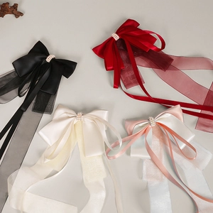Detail of satin and organza bow hair clips with faux pearl embellishments in multiple colors