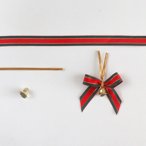 Detail set of red green striped Christmas ribbon bows with gold bells and metallic ties
