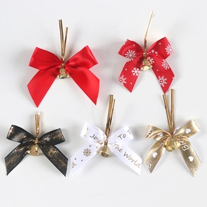 Detail of Christmas ribbon bows with gold bells and metallic ties for tree decoration