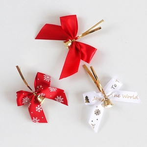 Detailed view of Christmas ribbon bows with gold bells and Joy To The World festive prints
