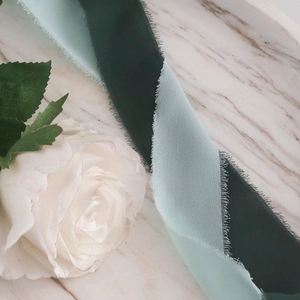 Close-up of handmade frayed edge chiffon ribbons in dark emerald and mint green tones