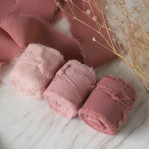 Detailed view of handmade frayed edge chiffon ribbons in gradient pink tones for bouquets