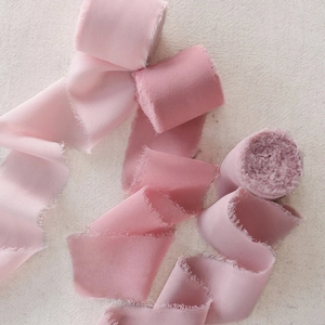 Detailed view of frayed edge chiffon ribbons in elegant dusty rose and pink tones