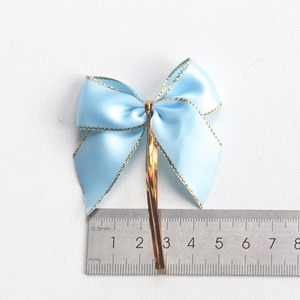 Light blue satin gift bow with gold edges and twist ties for packaging boxes