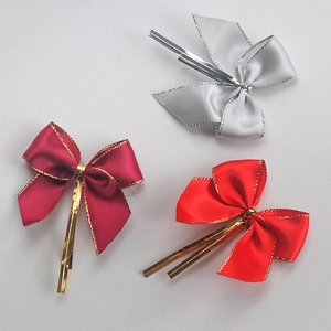 Detailed view of satin bows with metallic gold edges and twist ties for gift box decor