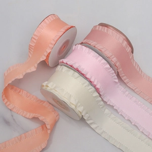 Detail of 4cm pleated ruffle ribbons in coral, pink, and cream for gift wrapping