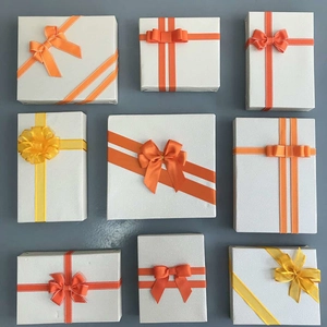 Detail of nine white gift boxes with assorted yellow and orange ribbon bow styles