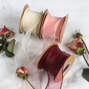 Fishtail yarn ribbons in cream, light pink, and burgundy on vintage kraft rolls