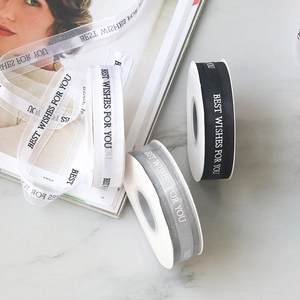 Flat lay of 2.5cm sheer organza ribbons with Best Wishes text on marble background