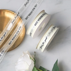 Close-up of white organza ribbon with printed Best Wishes and Just For You lettering