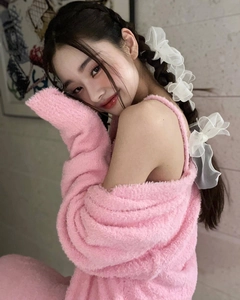 Detail of pink fuzzy knit cardigan with delicate white organza bow hair accessory