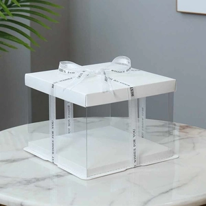 Close-up of square cake box with transparent sides and Best Wishes printed ribbon