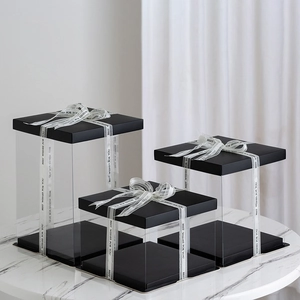 Three transparent gift boxes with black bases and white sheer 'Best Wishes' ribbons