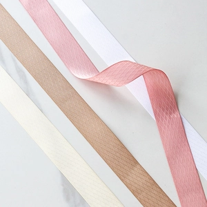 Detalle macro de cintas de poliéster con patrón de rombos en cinco colores para regalos DIY