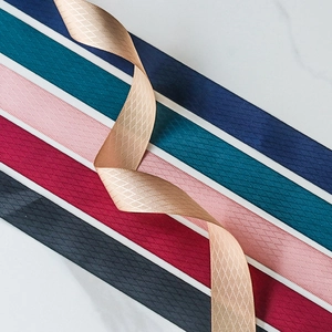 Detalle de cintas de poliéster con textura de diamantes en colores elegantes sobre mármol
