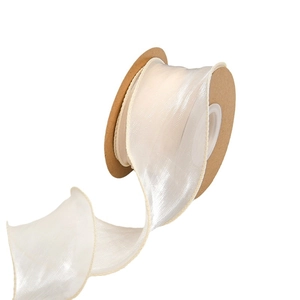 Ruban de mousseline crème semi-transparent avec bords ondulés sur bobine en carton