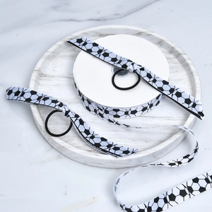 Detail view of soccer pattern grosgrain ribbons and elastic hair ties on marble tray